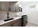 Modern laundry room with white quartz countertops, dark wood cabinets, and black faucet at 3485 S Clermont St, Denver, CO 80222