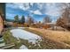 Wide shot of the back yard featuring a grassy lawn and covered patio at 12235 E Kentucky Ave, Aurora, CO 80012