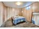 Basement bedroom featuring wood paneled walls, carpet, and a mirror at 12235 E Kentucky Ave, Aurora, CO 80012