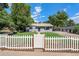 Charming gray house with white picket fence and landscaped lawn at 3100 Gray St, Denver, CO 80214