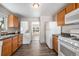 Open kitchen with wood cabinets, white appliances and view of living room at 3100 Gray St, Denver, CO 80214