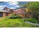 Grassy backyard with established plants, wood fence, and dining table at 1231 S Crystal Way, Aurora, CO 80012