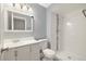 Bathroom featuring a vanity, toilet, and a walk-in shower with white tiling and a decorative accent stripe at 1231 S Crystal Way, Aurora, CO 80012