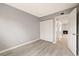 Empty bedroom with a closet and door, showcasing neutral paint and wood-look floors at 1231 S Crystal Way, Aurora, CO 80012