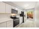 Modern kitchen featuring stainless steel appliances, light countertops, and access to outdoor space through sliding glass doors at 1231 S Crystal Way, Aurora, CO 80012