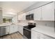 Well-lit kitchen with white cabinets, quartz countertops, stainless steel appliances, and a view from the sink at 1231 S Crystal Way, Aurora, CO 80012