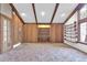 An open living room with a wood paneled walls, built in shelving and desk at 2978 Robb Cir, Lakewood, CO 80215