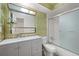 Updated bathroom with grey vanity and bamboo wallpaper at 3855 S Monaco St # 176, Denver, CO 80237
