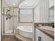 Bright bathroom showcasing a glass block window, walk-in shower and soaking tub at 3418 Oak Leaf Pl, Highlands Ranch, CO 80129