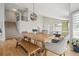 Bright dining room featuring stylish decor, vaulted ceilings, hardwood floors, and staircase access at 3418 Oak Leaf Pl, Highlands Ranch, CO 80129
