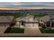 Inviting two-story home with a three car garage, solar panels, a manicured lawn, and sunset mountain views at 3418 Oak Leaf Pl, Highlands Ranch, CO 80129