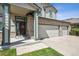 Inviting home exterior with a three car garage, stylish brick accents, and a manicured lawn at 3418 Oak Leaf Pl, Highlands Ranch, CO 80129