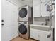 Functional laundry room with stacked washer and dryer and storage cabinets at 3418 Oak Leaf Pl, Highlands Ranch, CO 80129