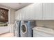 Functional laundry room with washer, dryer, ample cabinet space, and a utility sink at 8993 Stonecrest Way, Highlands Ranch, CO 80129