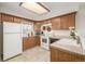 Functional kitchen with ample cabinetry, white appliances, and a light-filled window at 1911 S Hannibal St # H, Aurora, CO 80013