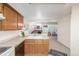 Efficient kitchen featuring wood cabinets, white appliances, and an open layout to the living area at 1911 S Hannibal St # H, Aurora, CO 80013