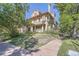 An inviting exterior view shows a well-maintained historic home with a charming brick facade and mature trees at 1000 N Logan St, Denver, CO 80203