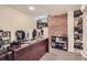 Basement office with exposed brick accent wall, built-in shelving, and a large desk area at 1000 N Logan St, Denver, CO 80203