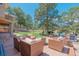 Spacious backyard featuring an outdoor seating area with comfortable wicker chairs and a fire pit, surrounded by trees at 19336 Queens Crescent Way, Monument, CO 80132