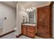 Charming bathroom featuring a wooden vanity, sink, and shower with neutral tile at 19336 Queens Crescent Way, Monument, CO 80132