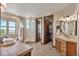 Elegant bathroom with soaking tub, glass block shower, and dual sinks, adjoining the walk-in closet at 19336 Queens Crescent Way, Monument, CO 80132