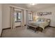 Bright bedroom with two windows, neutral carpet, a bed with a decorative comforter, and a wooden bench at 19336 Queens Crescent Way, Monument, CO 80132