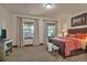 Bedroom with two windows, neutral carpet, a bed with a decorative comforter, and a wooden bench at 19336 Queens Crescent Way, Monument, CO 80132