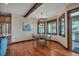 Dining area features hardwood floors, wood trim windows, modern lighting, and stainless steel refrigerator at 19336 Queens Crescent Way, Monument, CO 80132