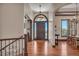 Inviting foyer featuring hardwood floors, elegant lighting, staircase, and beautiful wood door at 19336 Queens Crescent Way, Monument, CO 80132