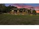 Charming exterior featuring a stone facade and manicured landscaping with a retaining wall at sunset at 19336 Queens Crescent Way, Monument, CO 80132