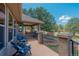 Covered patio features wood decking, railings, furniture, grill, and lush landscape views at 19336 Queens Crescent Way, Monument, CO 80132