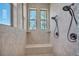 Beautiful tiled shower with dual shower heads, a built-in bench, and natural light from the windows at 19336 Queens Crescent Way, Monument, CO 80132