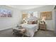 Comfortable main bedroom with gray carpet, decorative pillows, two windows, side tables, and decorative art at 6087 W 84Th Ave, Arvada, CO 80003