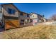 View of backyard featuring a spacious deck and outdoor play area between neighboring homes at 10438 Olathe Way, Commerce City, CO 80022