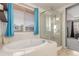 Elegant bathroom featuring a soaking tub, glass-enclosed shower, and bright natural light at 10438 Olathe Way, Commerce City, CO 80022
