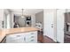Bright kitchen with white cabinets, butcher block countertops, and stainless steel appliances, leading into the living area at 10438 Olathe Way, Commerce City, CO 80022