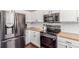 Contemporary kitchen showcasing stainless steel appliances, white cabinets, and wood countertops for a sleek, modern look at 10438 Olathe Way, Commerce City, CO 80022