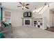 Cozy living room featuring a fireplace, ceiling fan, plush gray sofa, and staircase access at 10438 Olathe Way, Commerce City, CO 80022