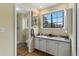 Bright bathroom featuring a double vanity, a window, and an adjacent shower room at 3105 Galileo Ln, Boulder, CO 80301