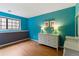 Charming bedroom with vibrant blue walls, a window, and stylish furniture on wood floors at 3105 Galileo Ln, Boulder, CO 80301
