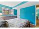 Bedroom featuring blue walls, wooden floors and a window providing natural light and view into the backyard at 3105 Galileo Ln, Boulder, CO 80301