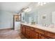 Bright bathroom featuring double vanity, large mirror, soaking tub, and a glass-enclosed shower at 5603 Van Bibber Ct, Golden, CO 80403