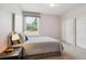 Cozy bedroom with a queen bed, soft grey walls, and bright natural light from the large window at 5603 Van Bibber Ct, Golden, CO 80403