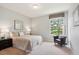 Bright bedroom featuring neutral tones, a comfortable chair, and a large window view of the yard at 5603 Van Bibber Ct, Golden, CO 80403