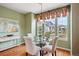 Bright dining room with hardwood floors, decorative window treatment, and a glass-top table at 5603 Van Bibber Ct, Golden, CO 80403