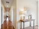 Hallway featuring wooden flooring, white walls, and a decorative table with a lamp and painting at 5603 Van Bibber Ct, Golden, CO 80403