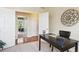 Spacious office with a dark wood desk, chair, and view into the living room with hardwood flooring at 5603 Van Bibber Ct, Golden, CO 80403