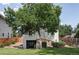 Backyard view of the home featuring lush green lawn and a large shade tree at 2895 S Sherman St, Englewood, CO 80113