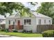 Charming single story home featuring a red door, tidy landscaping, and mature trees at 2895 S Sherman St, Englewood, CO 80113
