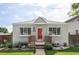 Charming bungalow-style home with a red front door, manicured lawn and walkway at 2895 S Sherman St, Englewood, CO 80113